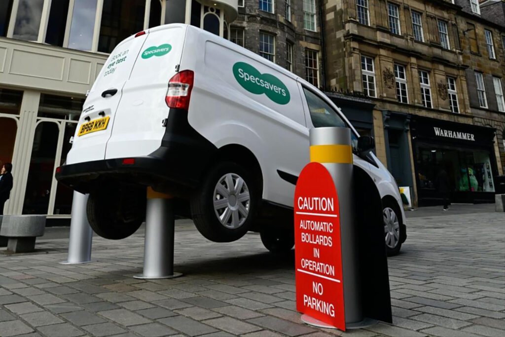 White van with Specsavers branding stuck on a bollard.