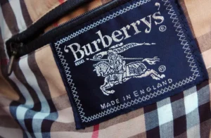 Burberry British heritage brand blue label. Stitched onto classic Burberry cream plaid coat print.