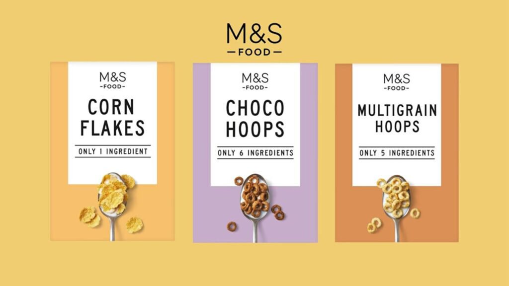 M&S' three cereals with minimal design that mentions the ingredients on the packaging, the cereals are cornflakes, choco hoops, and multigrain hoops in yellow, violet, and orange respectively.